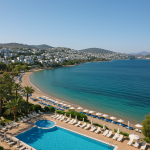 A natural seaside view of Bodrum, showing an all-inclusive resort with clear waters and sun loungers—capturing the relaxed vibe of holidays in Bodrum Turkey all inclusive.